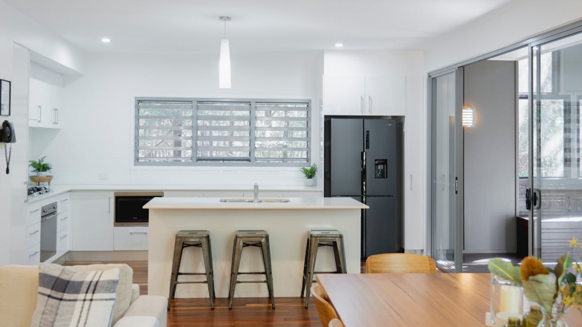 Spacious fully equipped kitchen with breakfast bar, double fridge, oven, and dishwasher.
