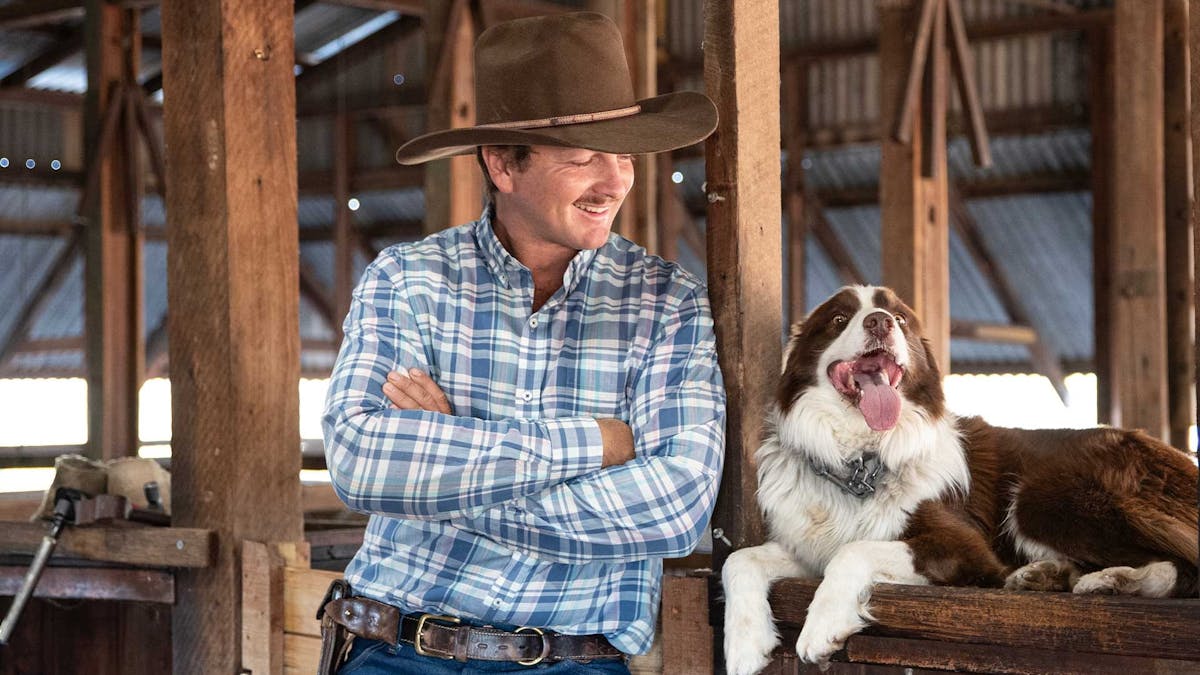Jeremy Kinnon with his dog Banjo, in the shearing shed
