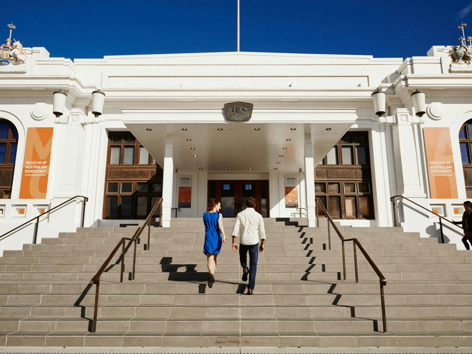 Two people walk up the steps of Old Parliament House