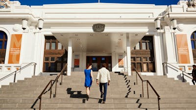 Two people walk up the steps of Old Parliament House