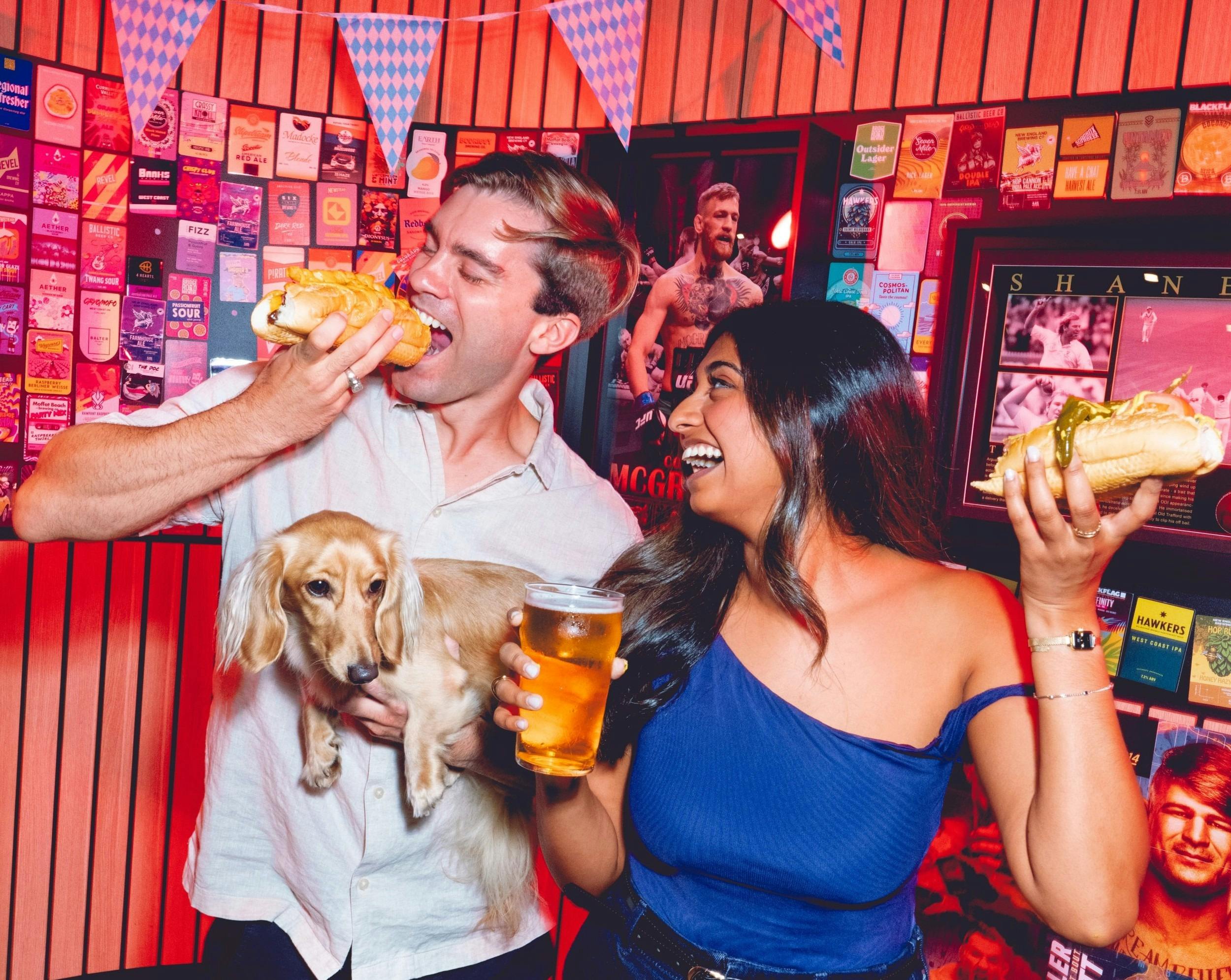 People eating hotdog and drinking beer