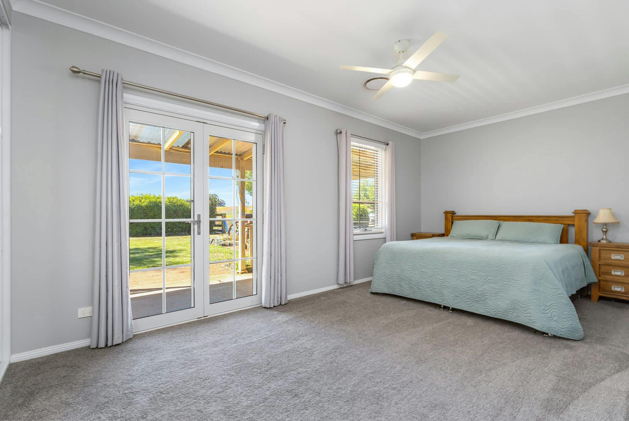 King bed with side tables, french doors, curtains and carpet