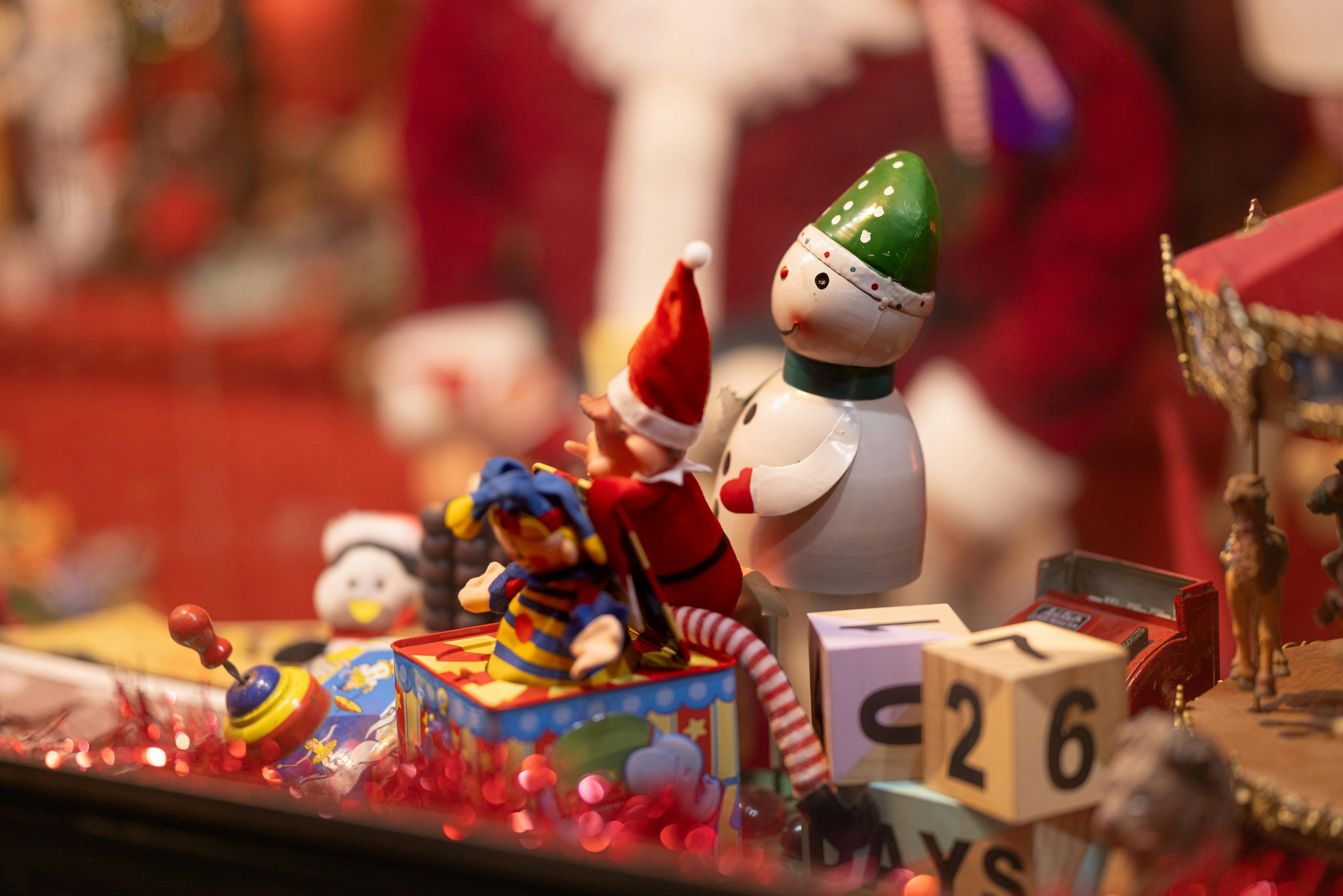 A small elf and snowman play with a jack-in-the-box inside the Emporium