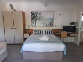 Studio room containing Queen size bed and single, kitchenette, bathroom and balcony