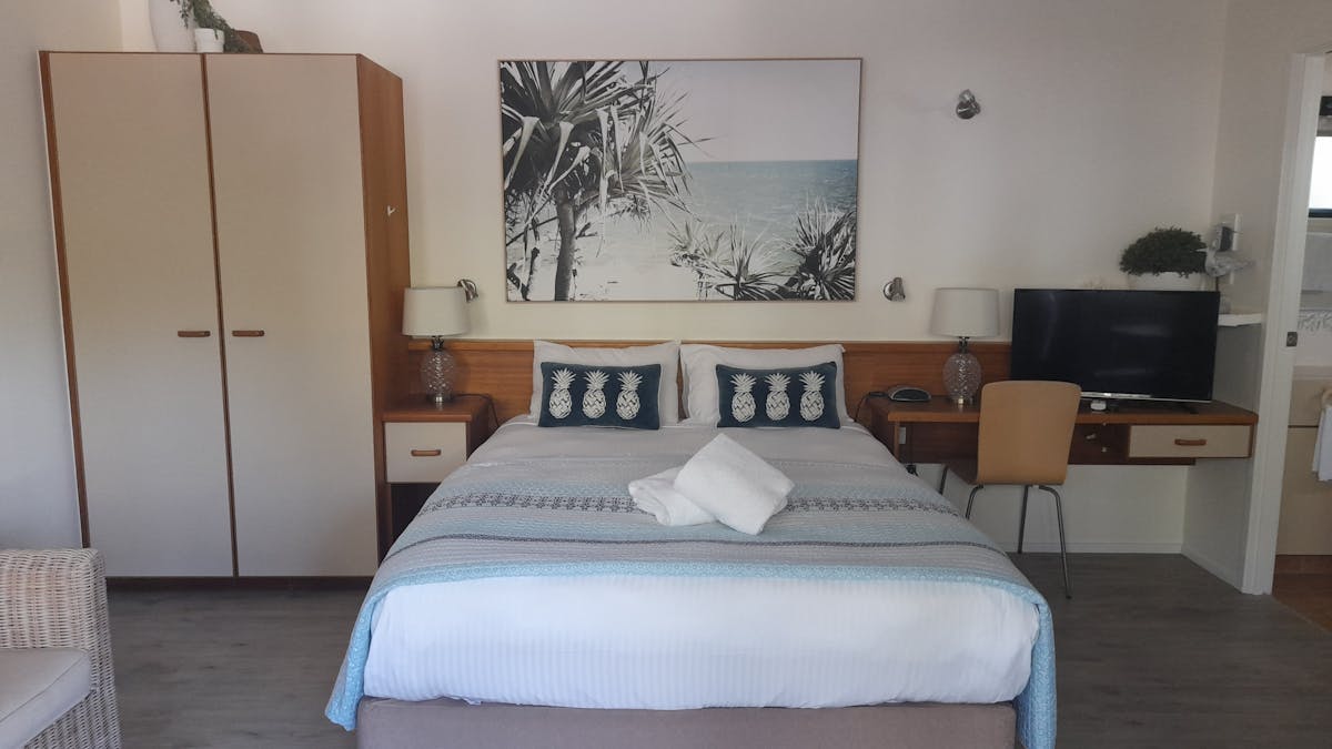 Studio room containing Queen size bed and single, kitchenette, bathroom and balcony