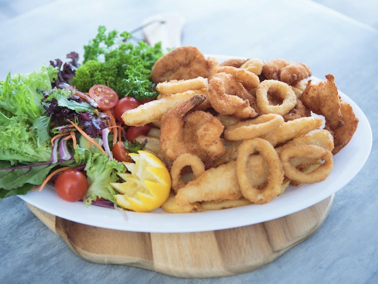 Seafood platter with fish bites, calamari, chips and fresh salad.
