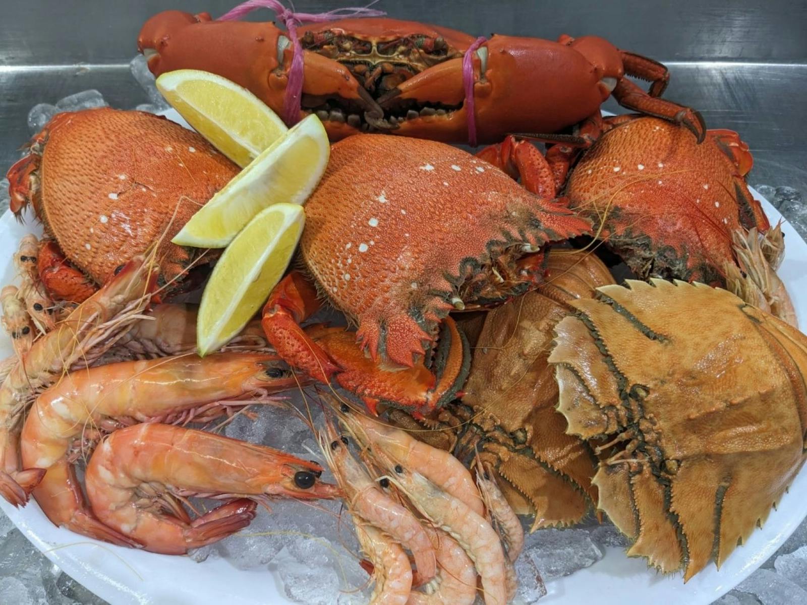 Uncooked crabs and prawns with lemon wedge