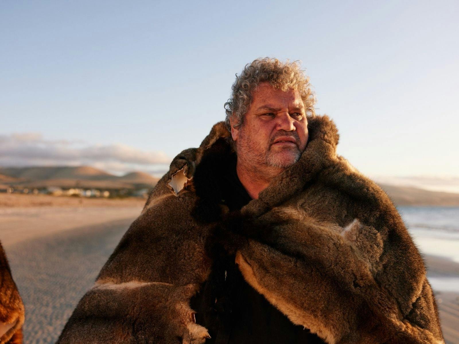 A man wearing a possum skin cloak