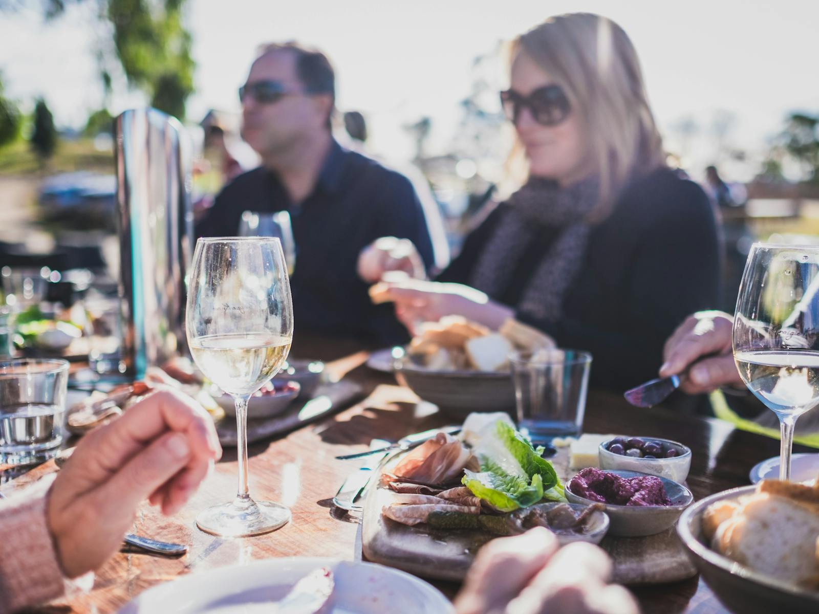 A group of people enjoying lunch and wine, outdoors at Craigie Knowe Vineyard