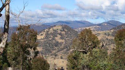 Three hikers on a trail looking at the views from Mt  Tennent in Namadgi National Park