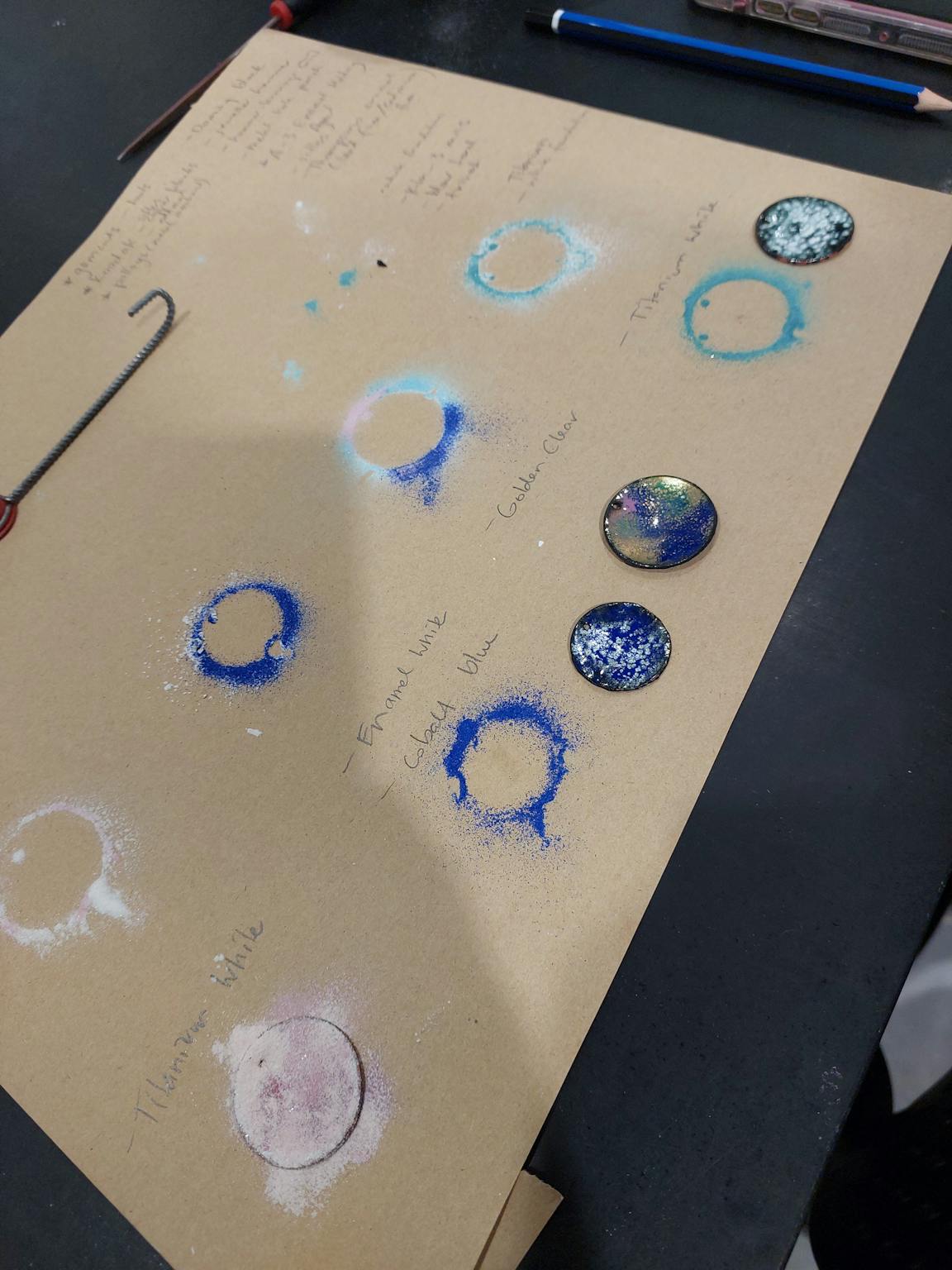 The image shows the outline of discs in blue and green enamel powders.