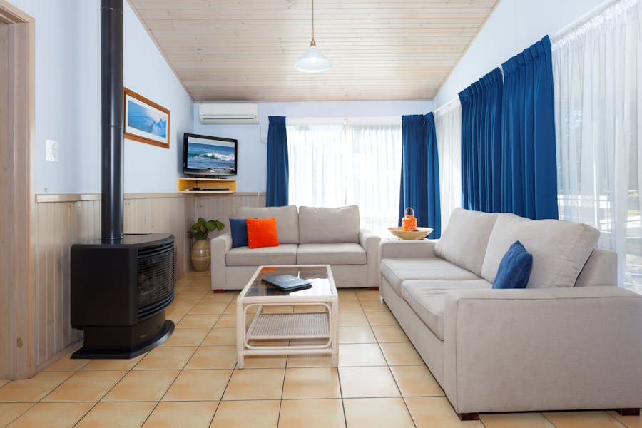 Warm up with the fireplace in the lounge room of Cabin 14 at Werri Beach Holiday Park