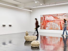 sculptures and paintings in a gallery with white walls