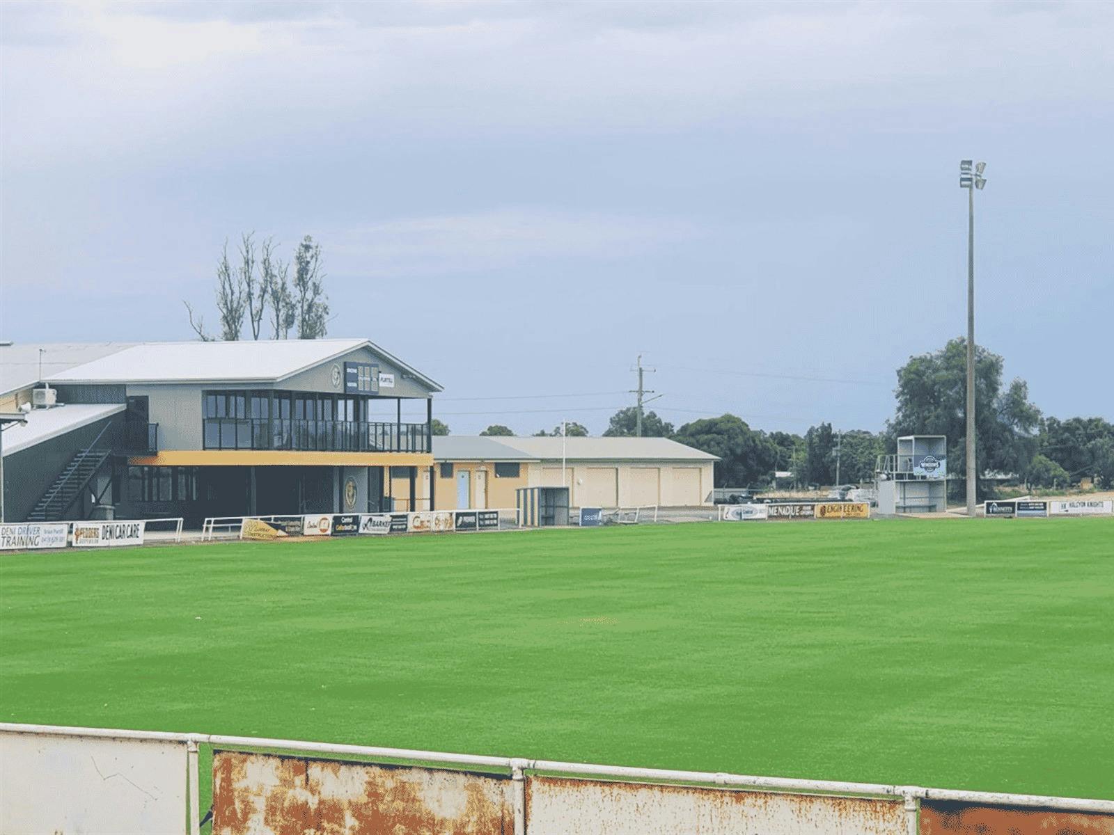 A green AFL oval with shelter in the background