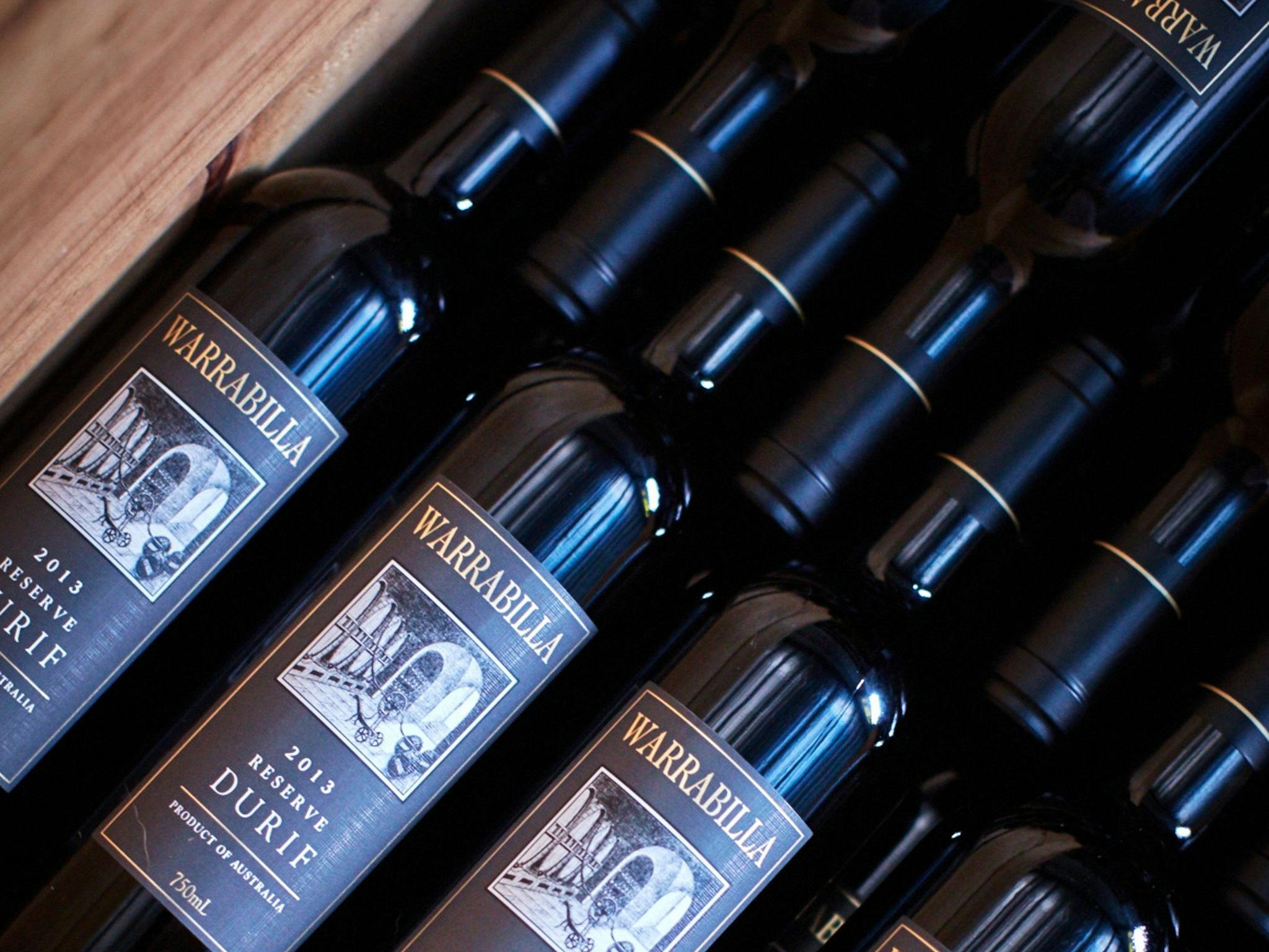 An artful image of many bottles laying in a wooden box- all with pristine grey labels facing up