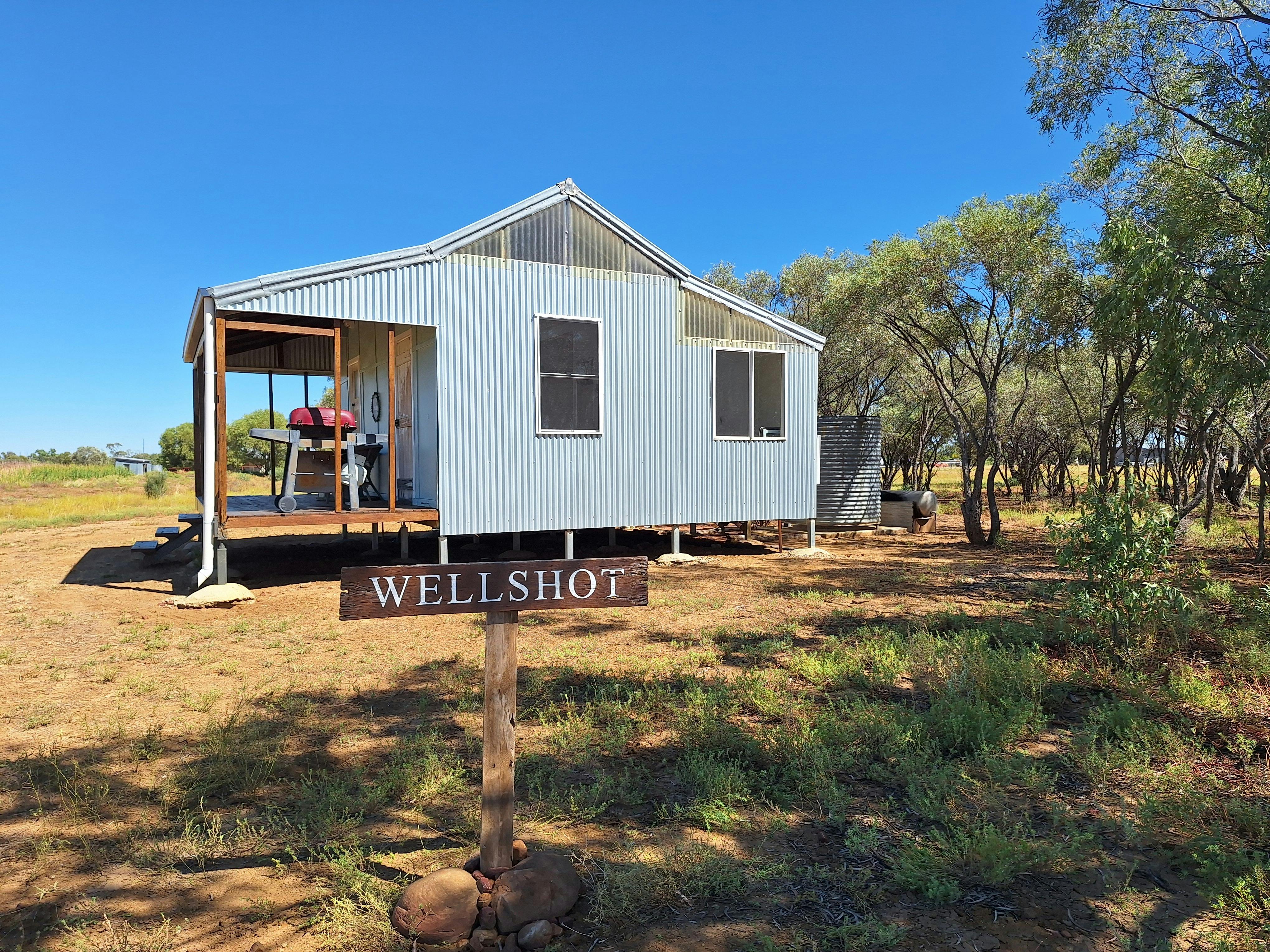 An iron cottage in an outback setting with a clear blue sky