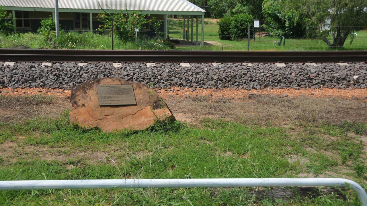 Memorial in the foreground, new railway line and historic station in the background.