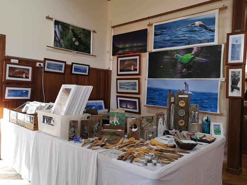 complete market stall displaying photography, carved spoons, paintings