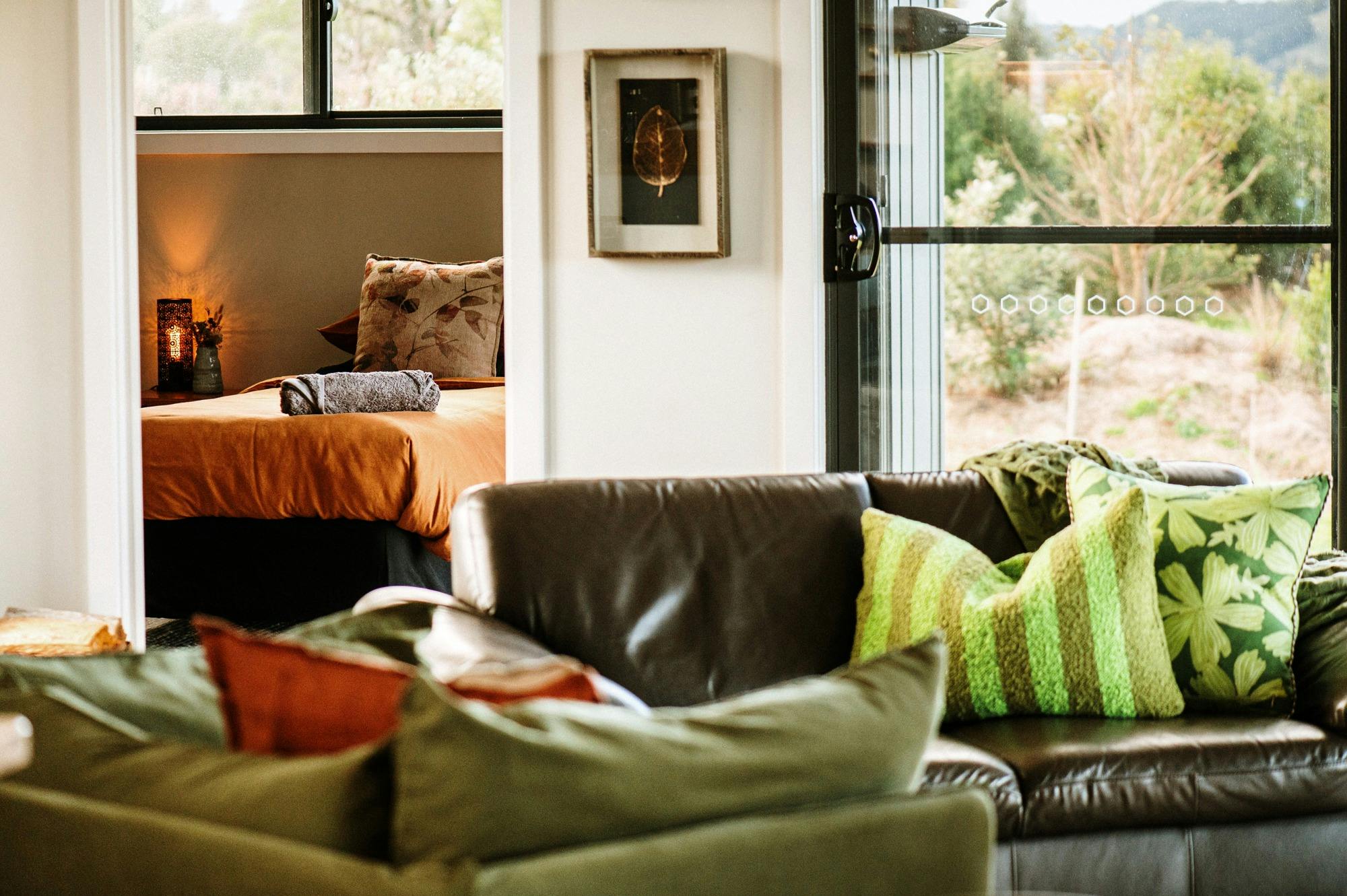 Photo of living space showing second bedroom in background and country framland through sliding door