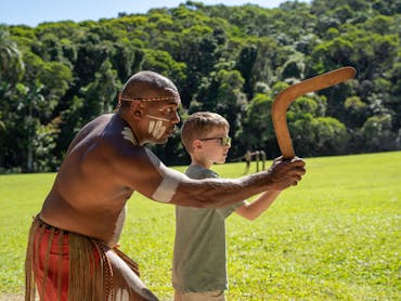 A pamagirri guide showing a child how to throw a boomerang.
