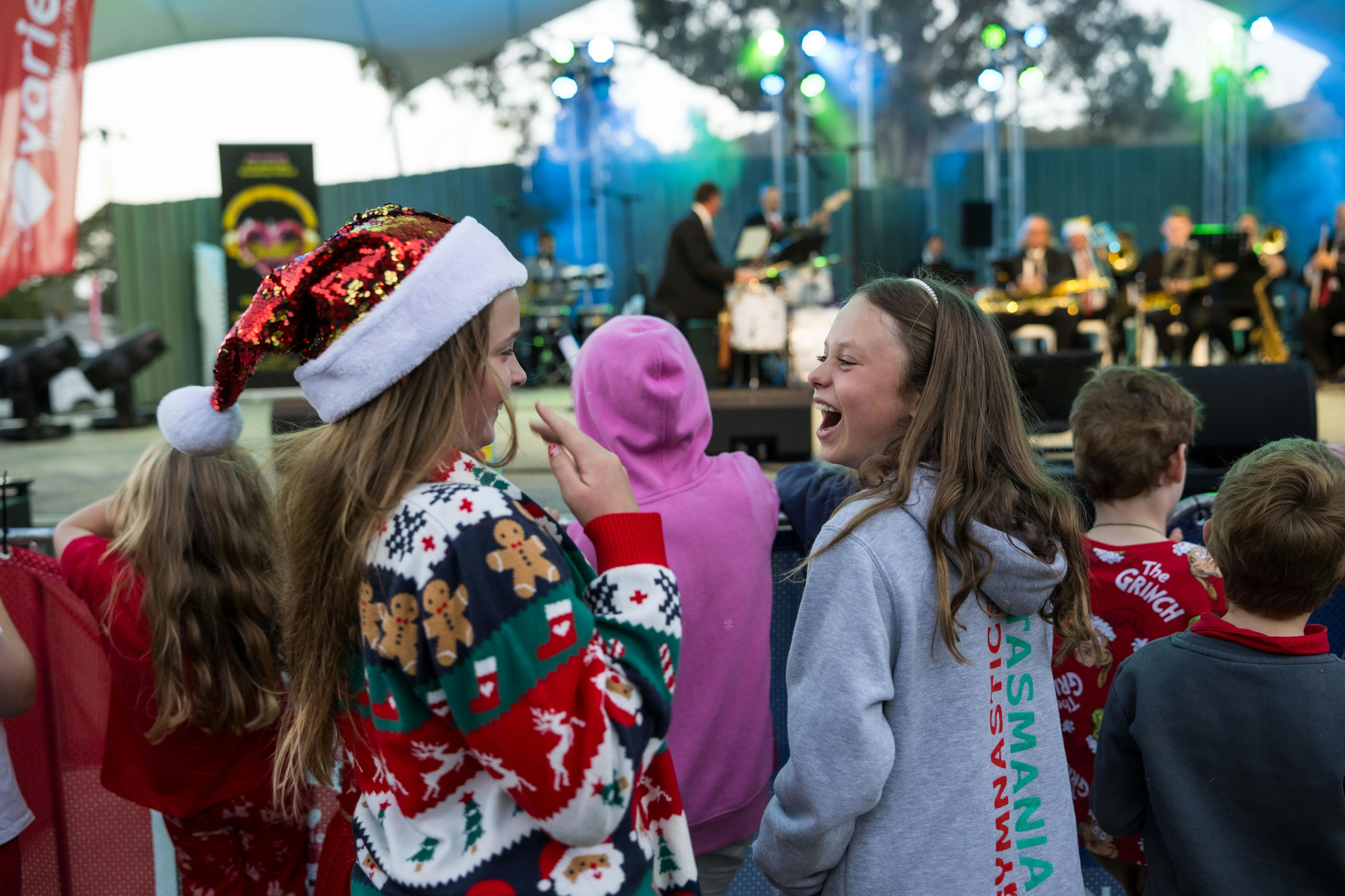 Two 10 year old girls in the crowd enjoying the performance at the Variety Carols by Candlelight