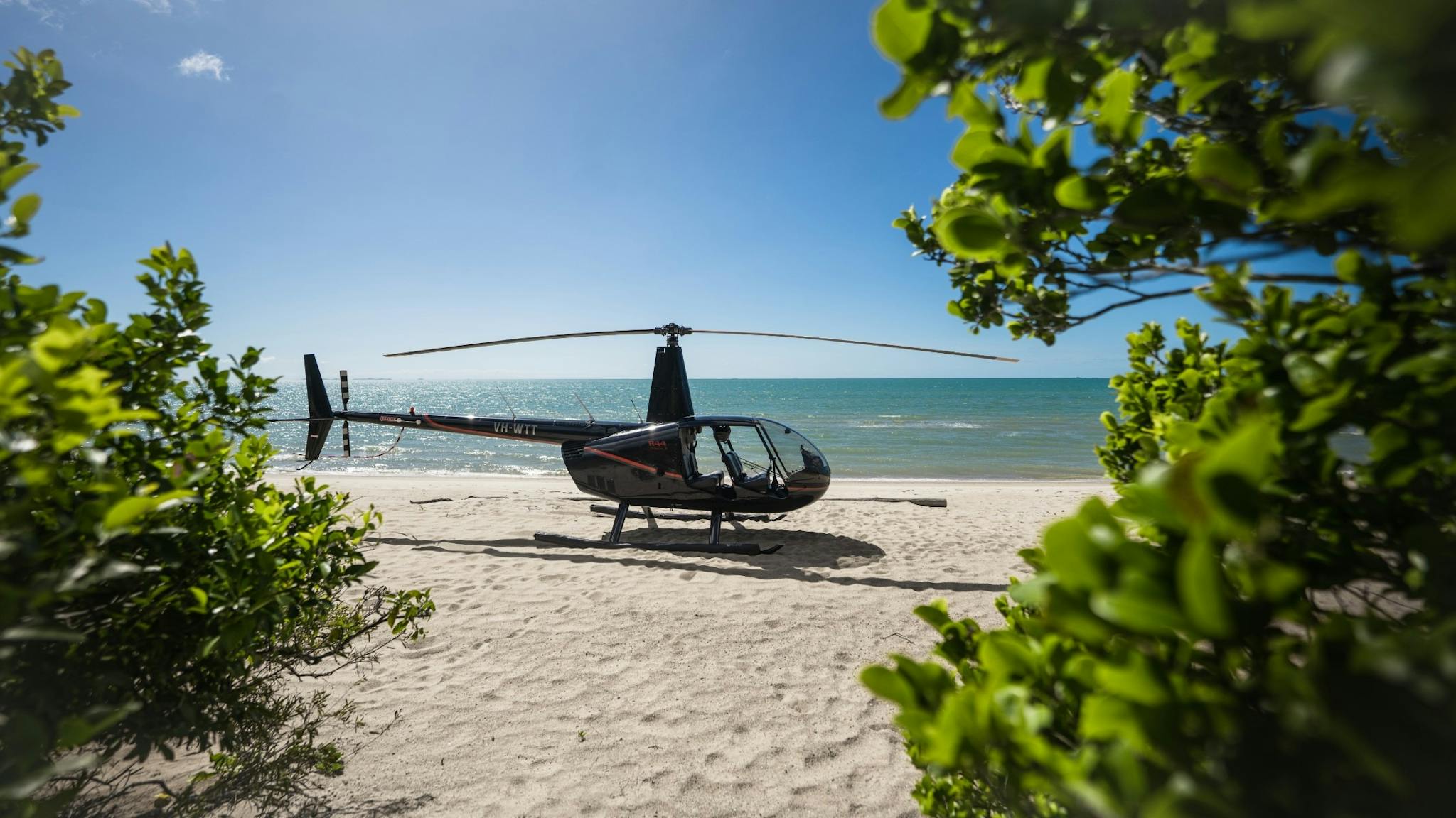 Helicopter on a beach with blue skies behind it - ready for take off Helicopter on a beach with blue skies behind it - ready for take off