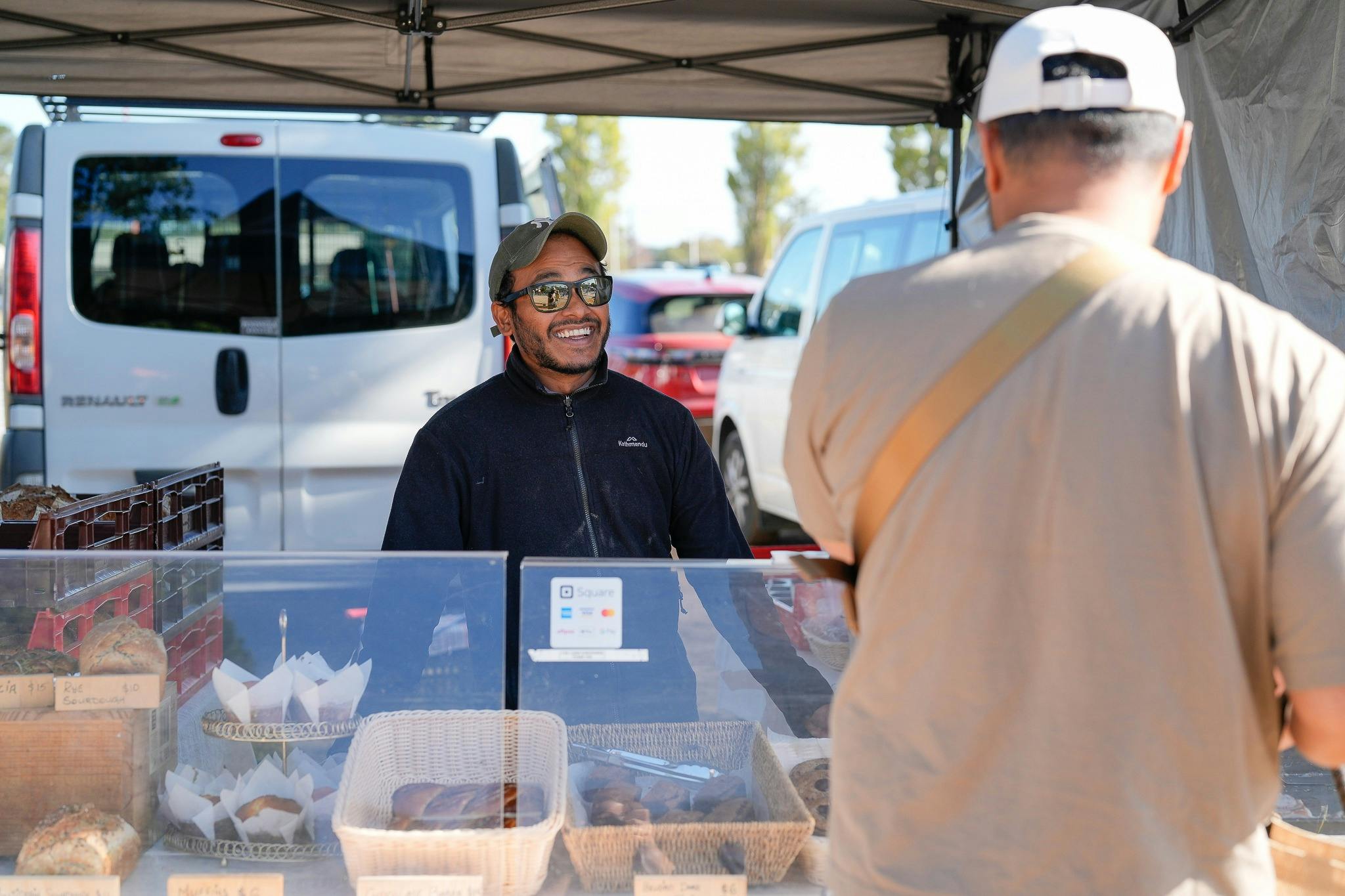 Customer buying fresh bread from Balus on a beautiful sunny market day