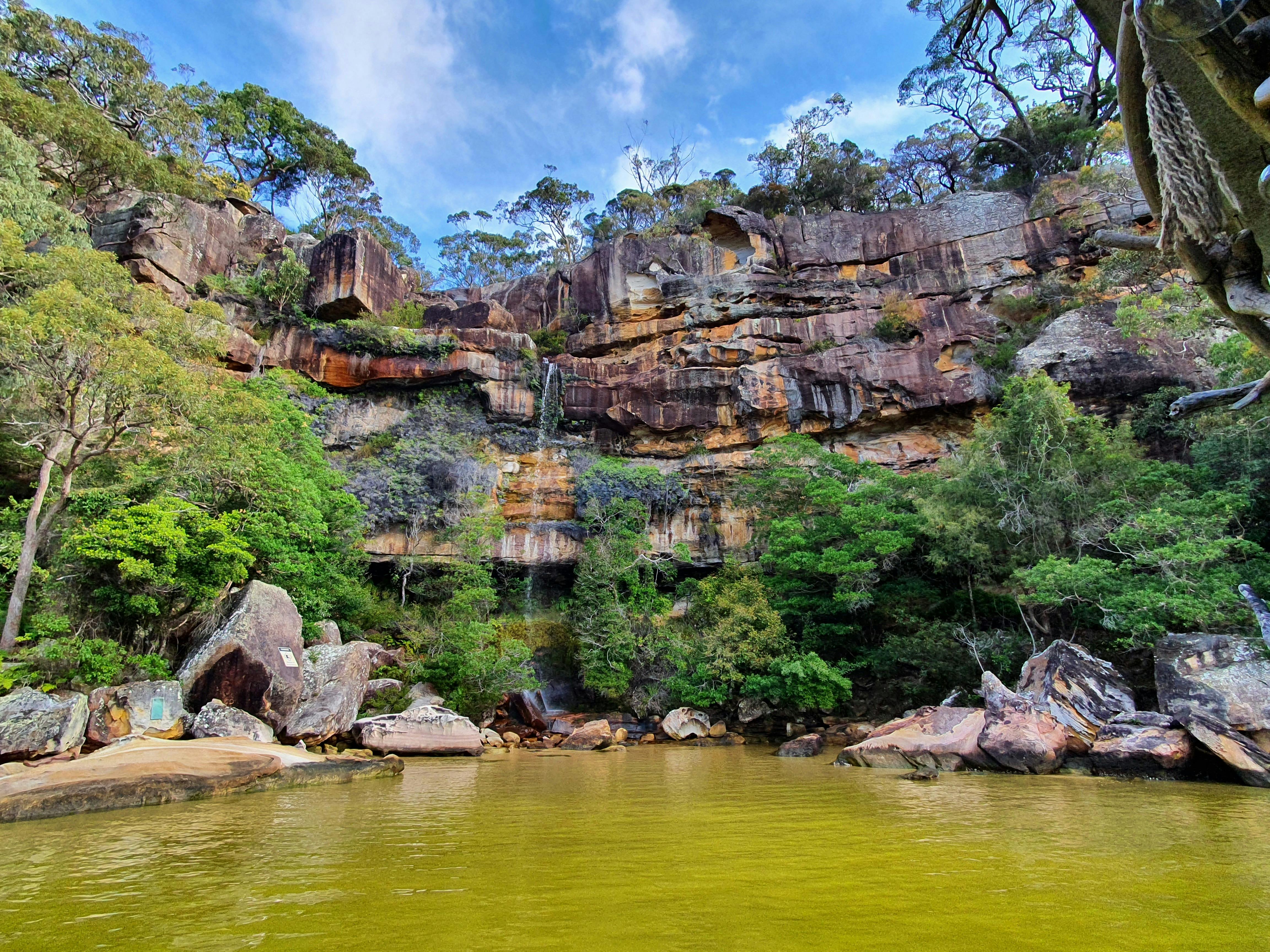 Sandstone escarpment Hawkesbury river Brooklyn with native Australian bush riverbanks and waterfall