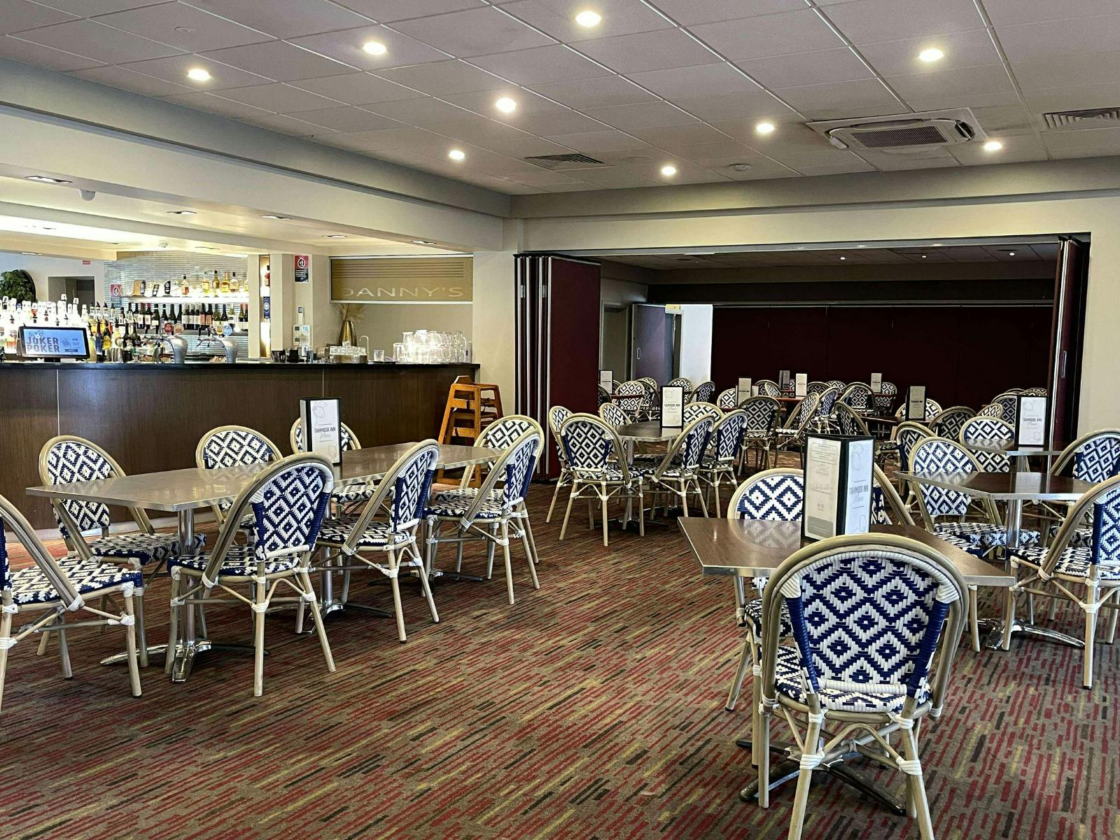 タムール インのビストロの座席エリアにあるテーブルと椅子