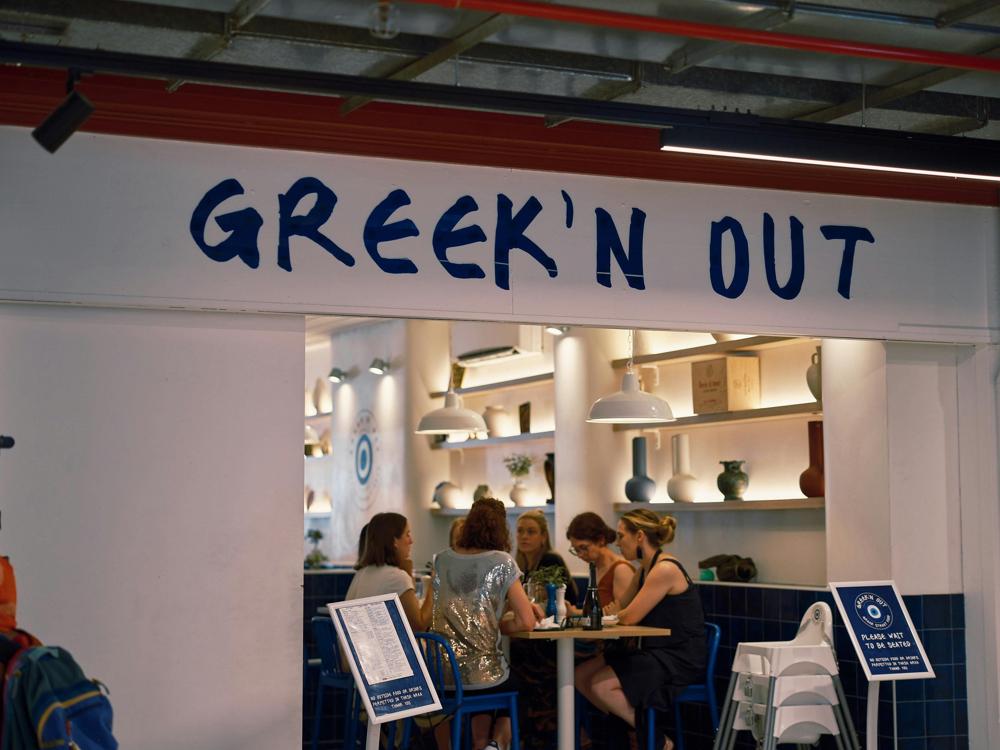 Diners seated inside Greek'n Out restaurant at South Melbourne Market.