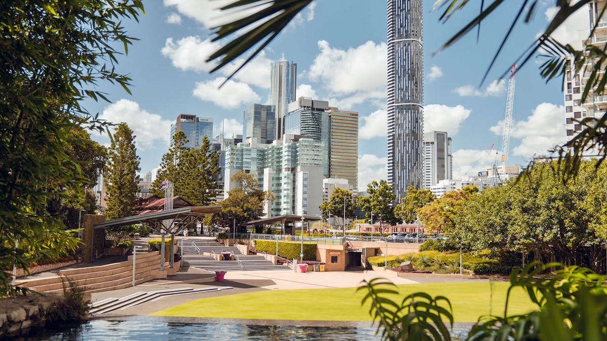Large green lawn area with city building backdrop