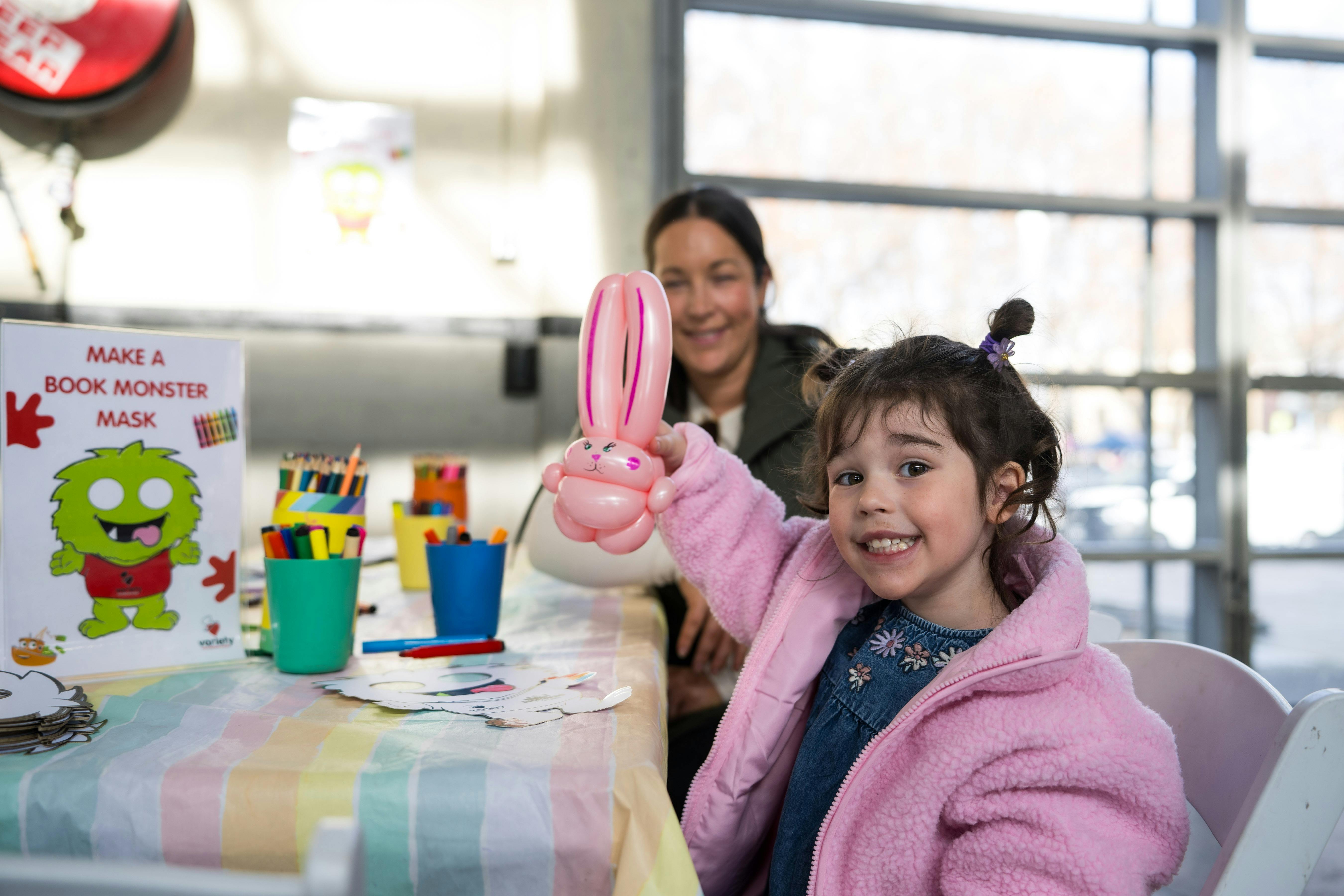small girl with pig tails doing balloon art at the Variety Monster Bookfair