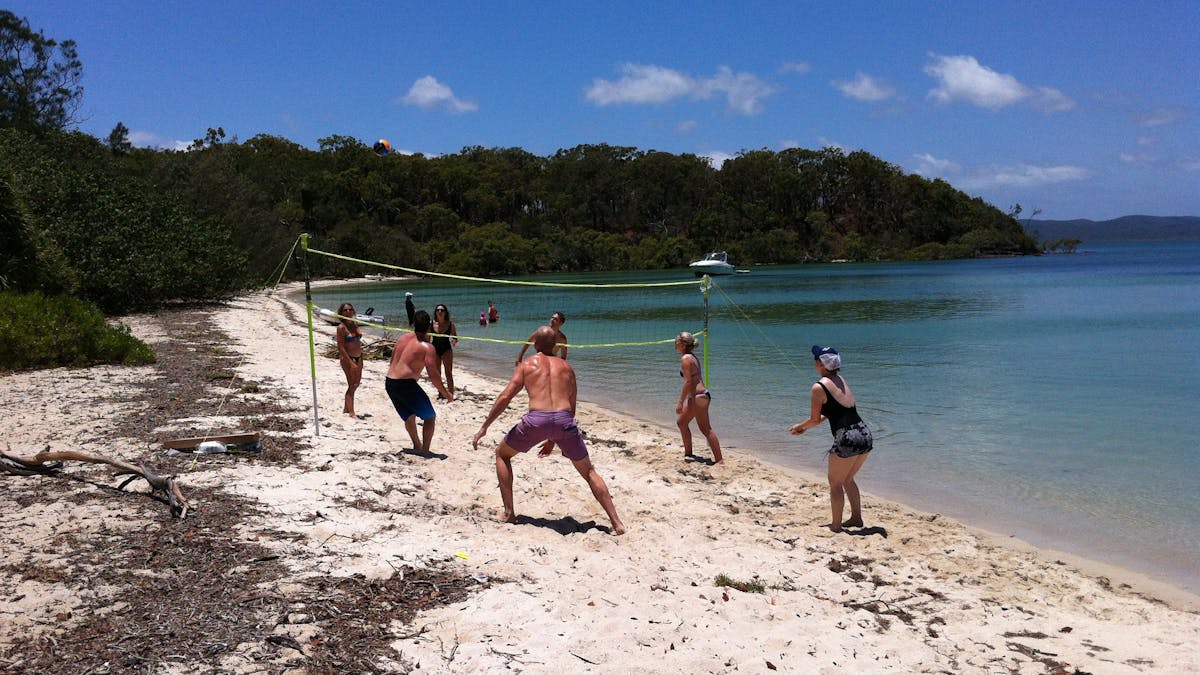 Passengers enjoying beach volleyball at Peel Island, Moreton Bay with Brisbane Yacht Charters