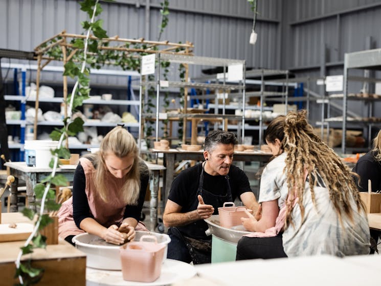 group of people on pottery wheels