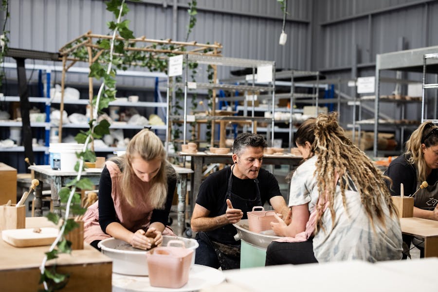 group of people on pottery wheels