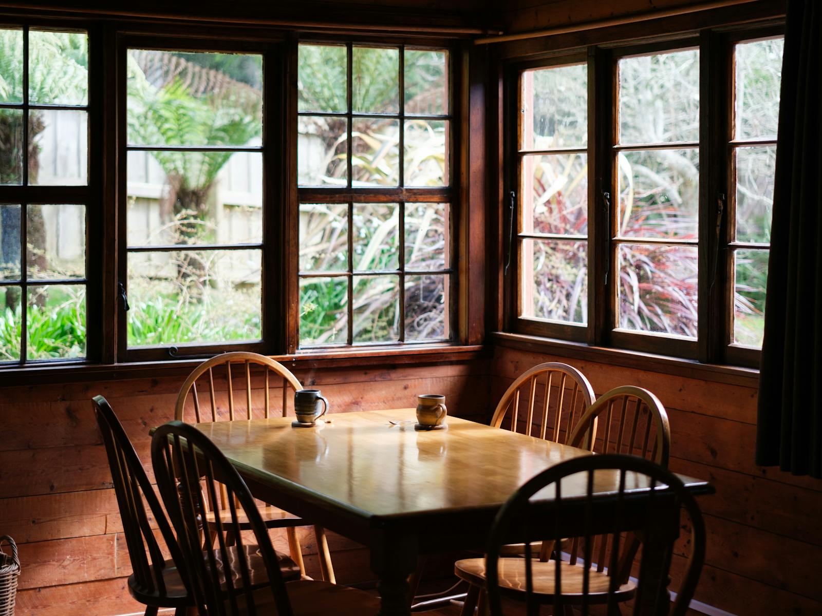 Wooden dining table in a room with large wooden windows