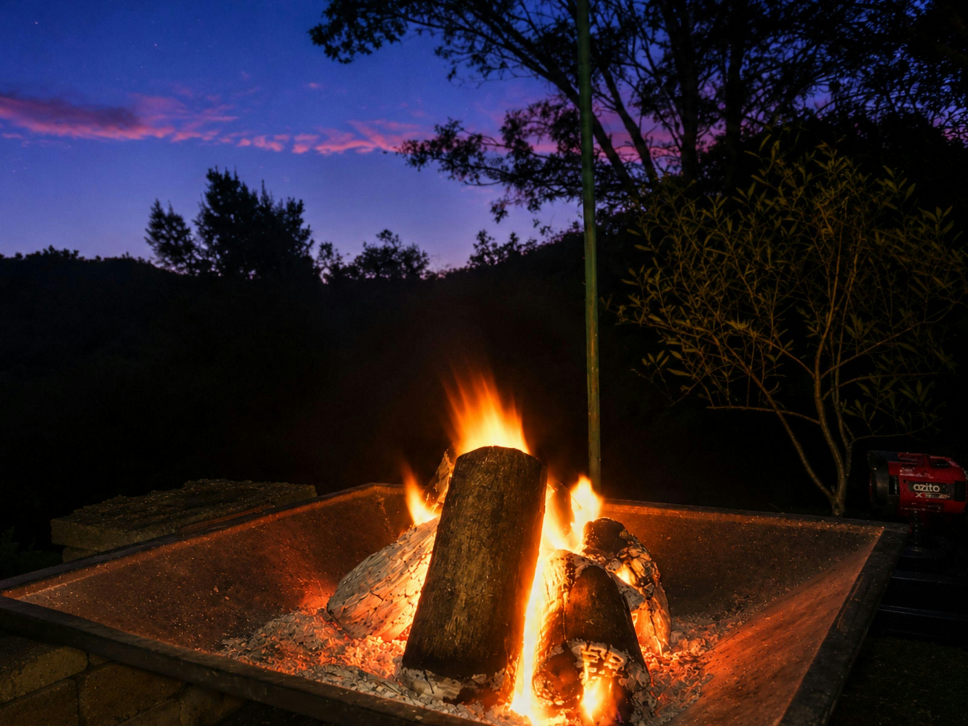 Fire pit glowing at night during winter at K2 River Island Nature Retreat.