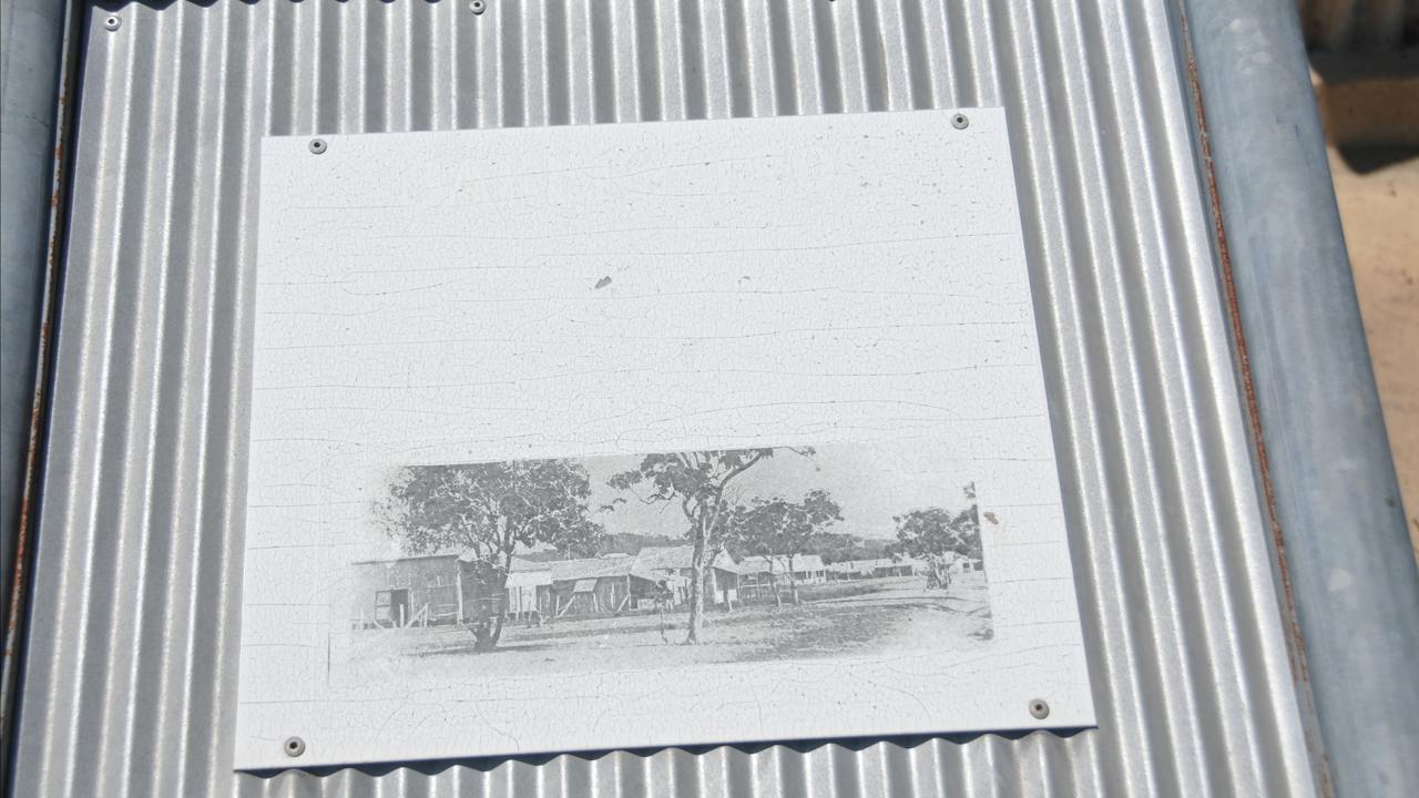 Faded and illegible interpretative panel at the site.