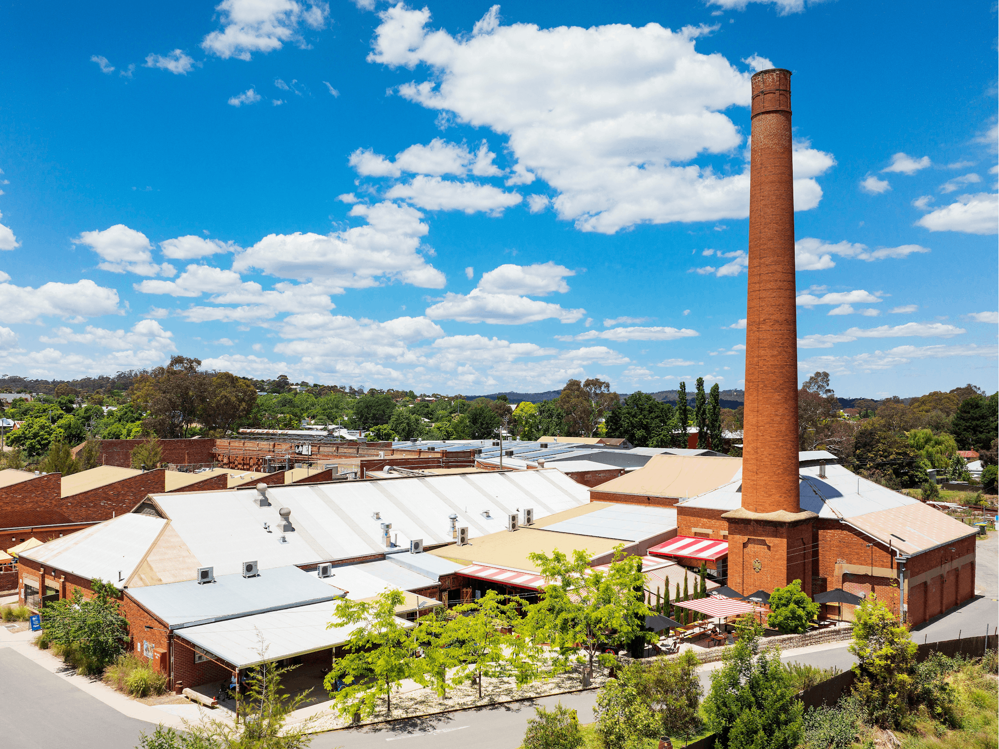 Aerial view looking at variety of old industrial buildings and chimney stack now home to businesses