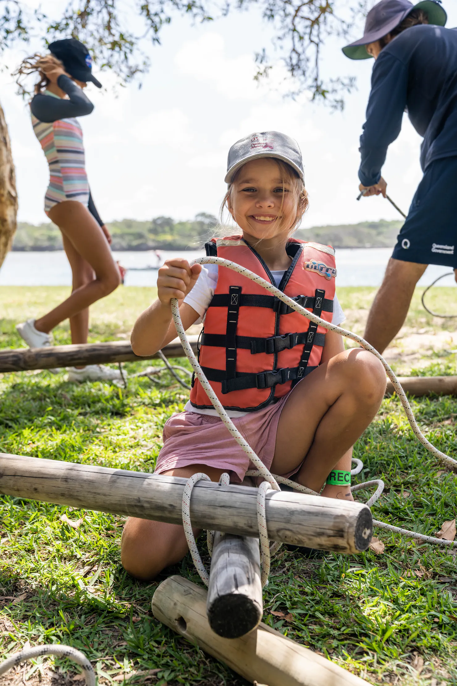Young girl, learning to tie a knot to secure a raft