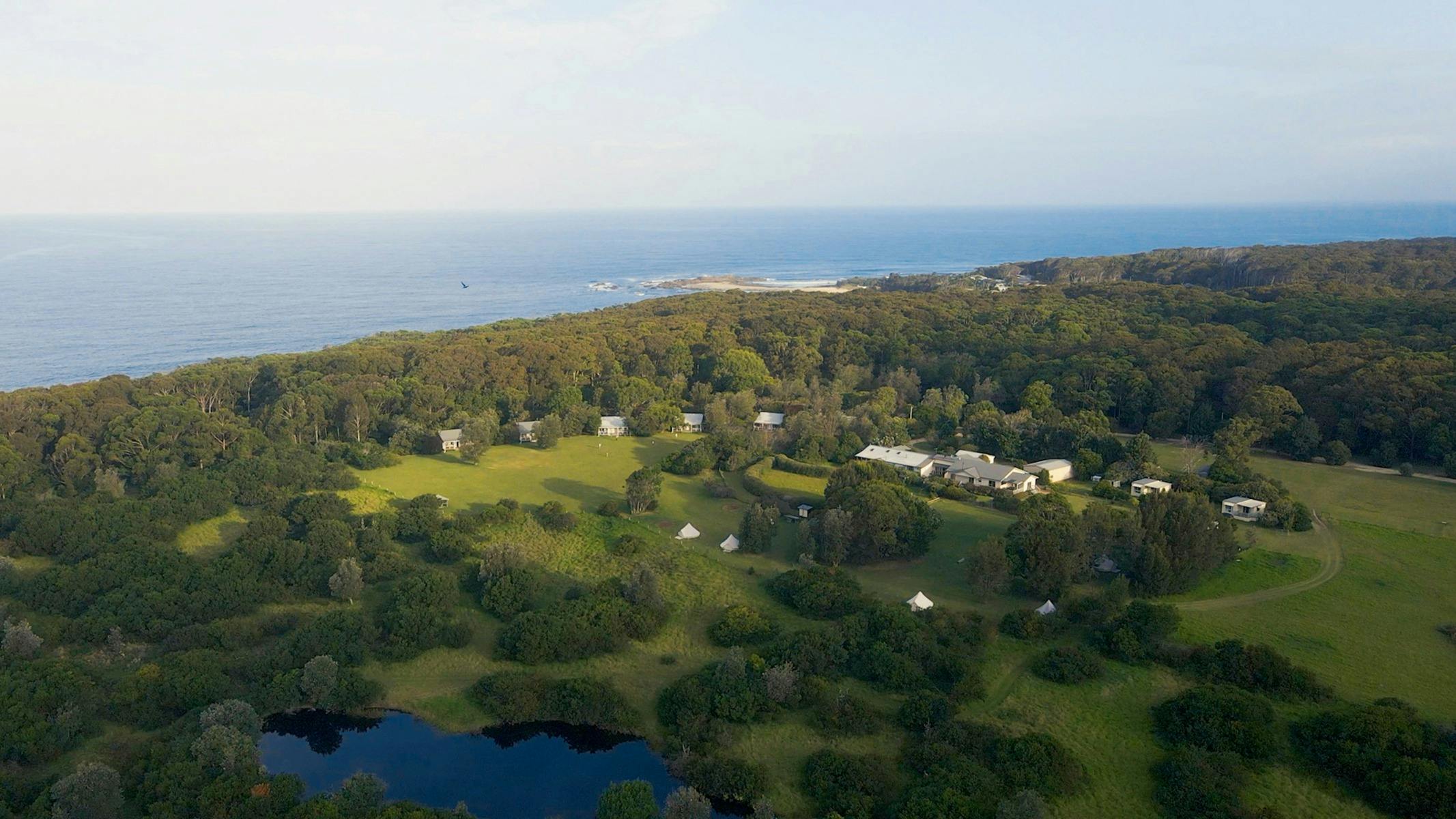 Ariel view of the property surround by green bush land and right next to the ocean