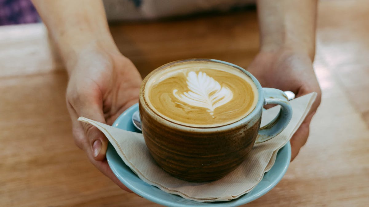 Flat white coffee being served by a waitress