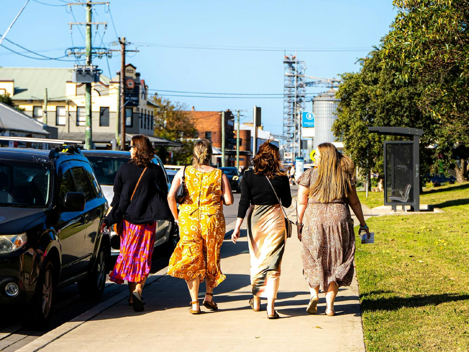 Four women dressed in fun outfits walk the streets of Carrington during Pours 2025