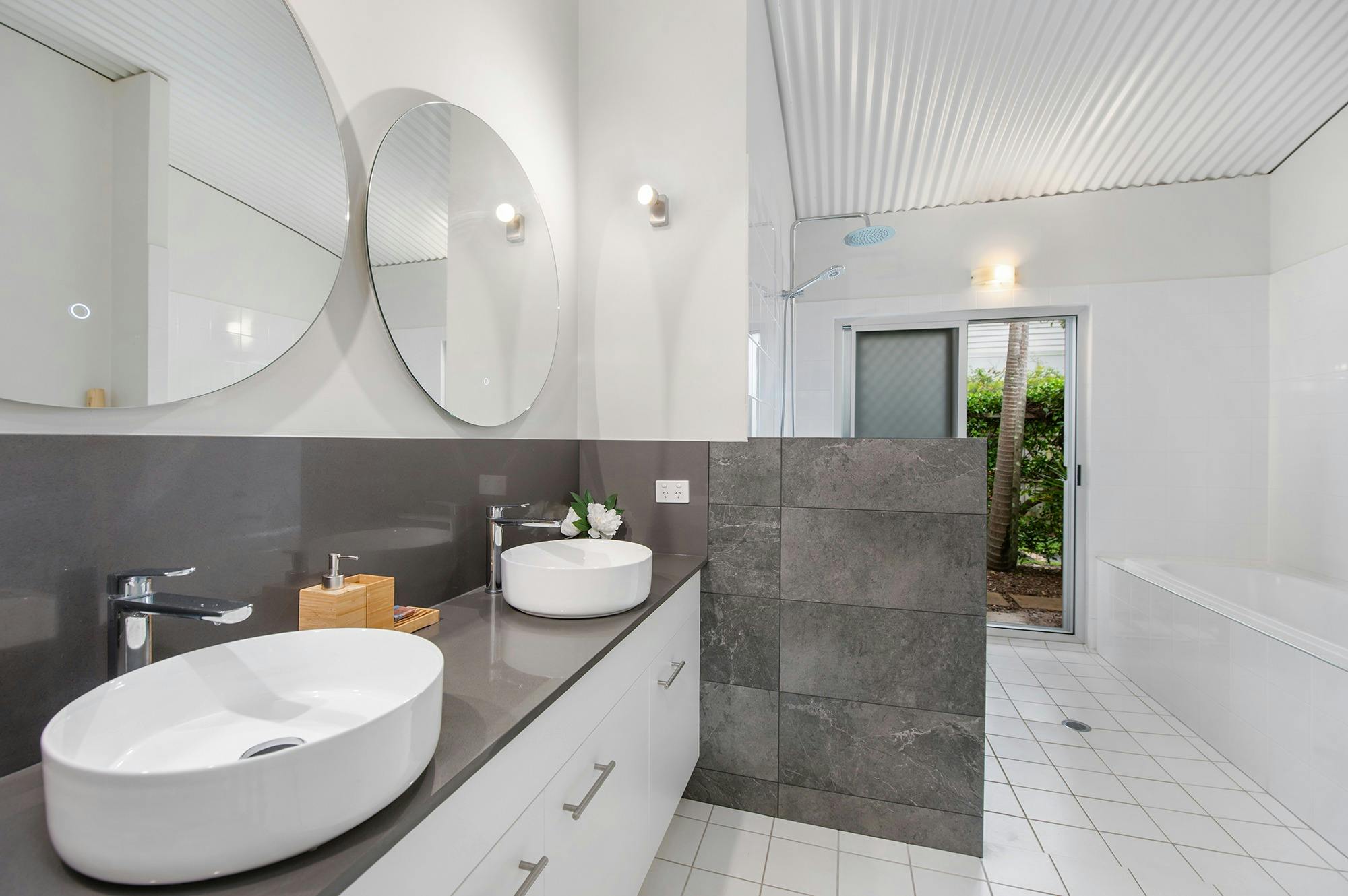 The expansive bathroom with rain shower and separate bathtub to soak in