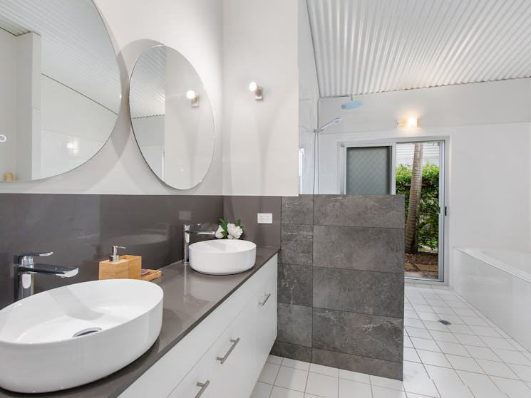 The expansive bathroom with rain shower and separate bathtub to soak in