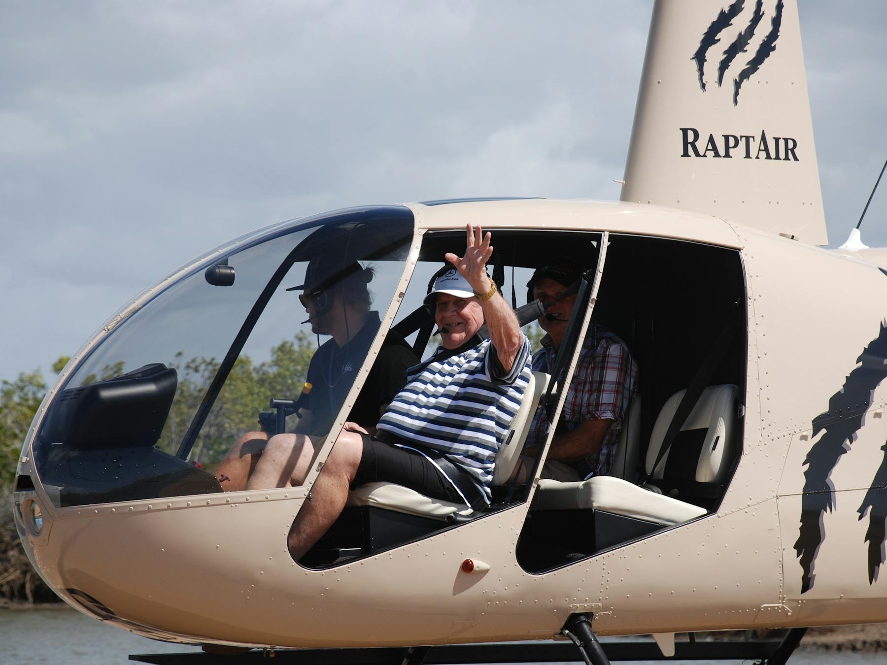the guests are sitting in the helicopter waving out of the window - flying with no doors
