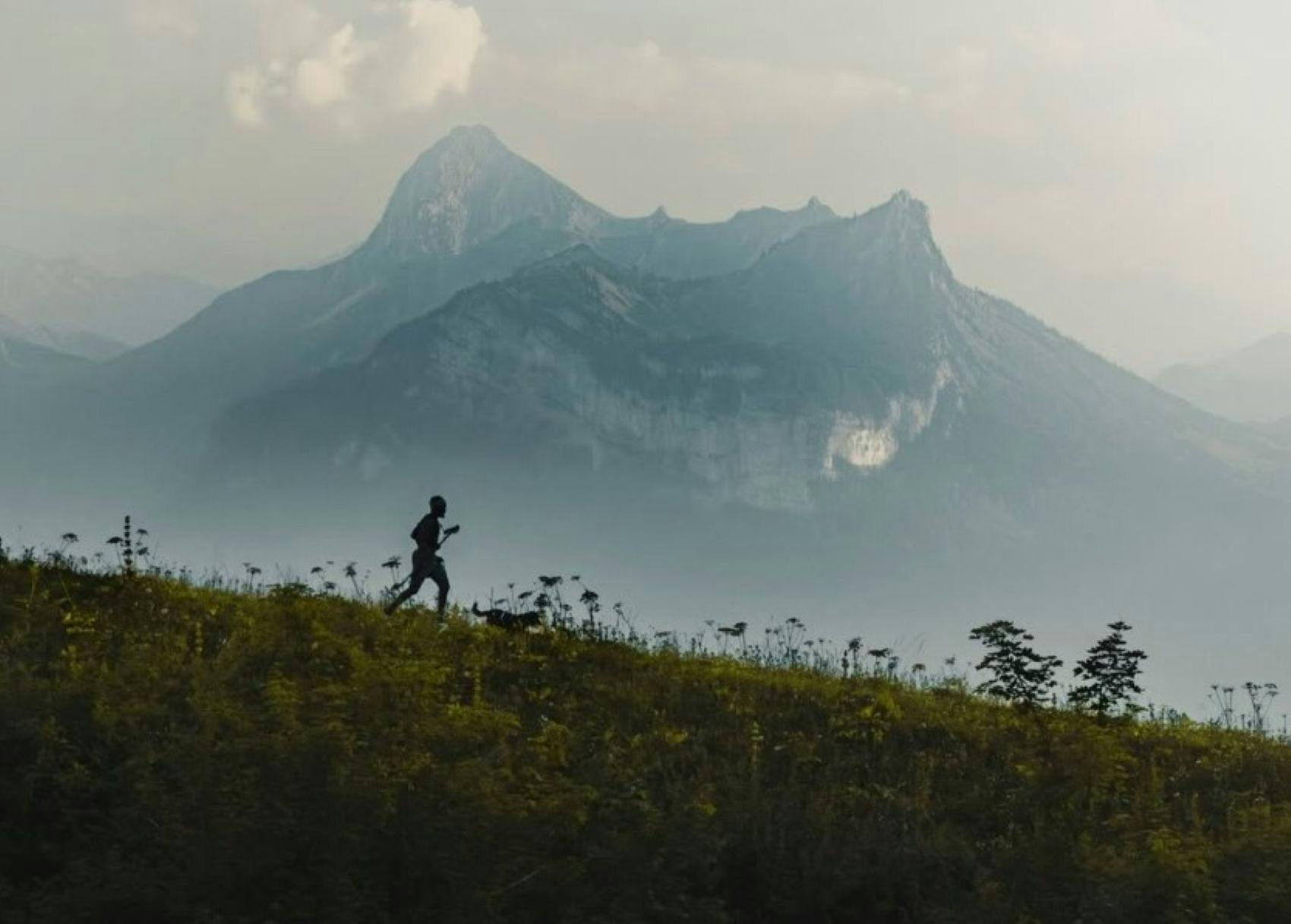 silhouette of runner with mountains in background