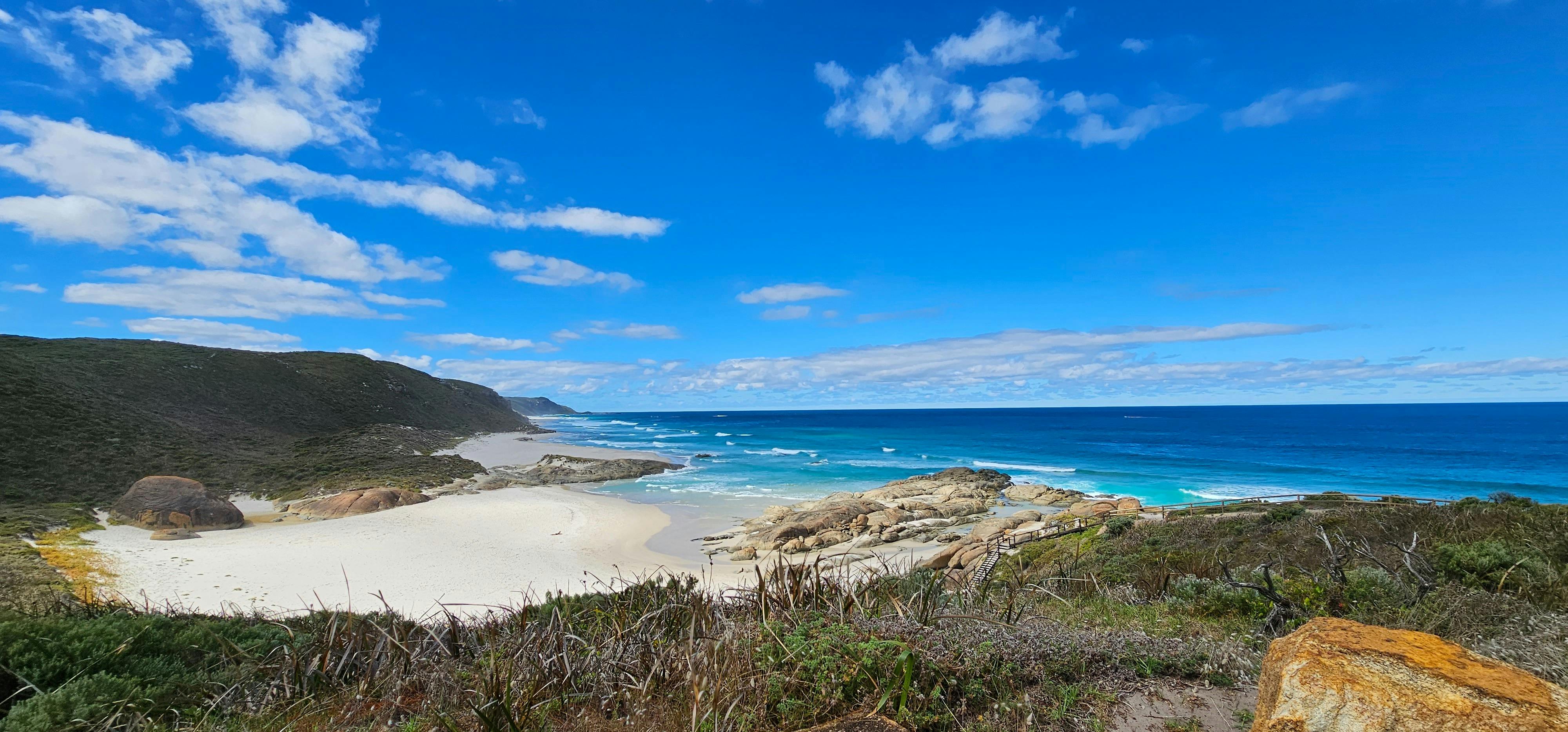 Secluded bay with turquoise blue water, white sand, and blue sky on a sunny day