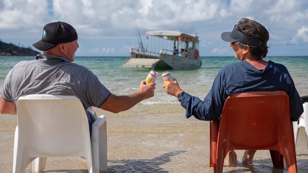 Mates having a beer on a beach