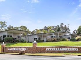Entrance to Blue Lake Holiday Park showing brick wall with signage of place name and  Villas